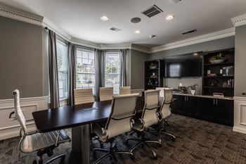 A conference room with a table and chairs and a tv